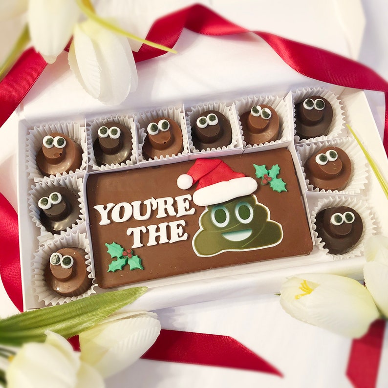 Solid chocolate bar surround by 10 little poop emoji shaped chocolates. Bar reads You're the shit in fondant lettering