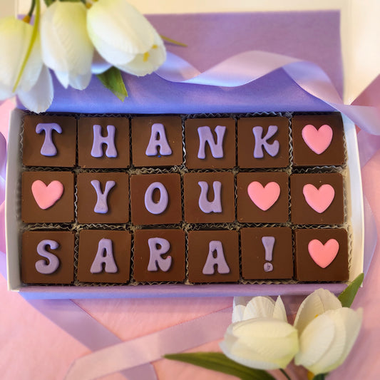 18 Solid chocolate squares spell out thank you with fondant lettering and hearts.