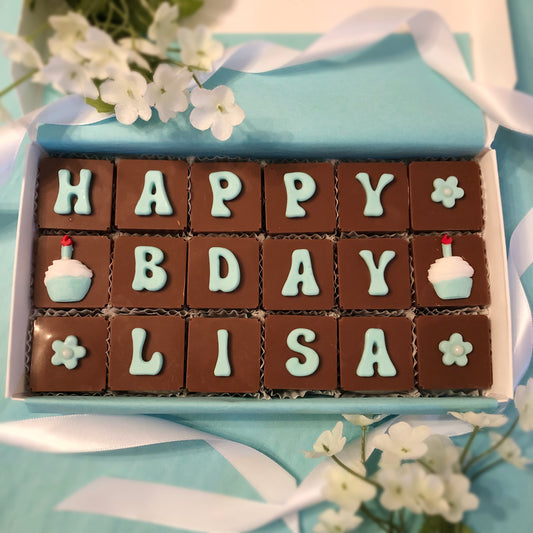 Solid square chocolates with one fondant letter on each, spell out - Happy Birthday with flowers, cupcakes and your personalized name